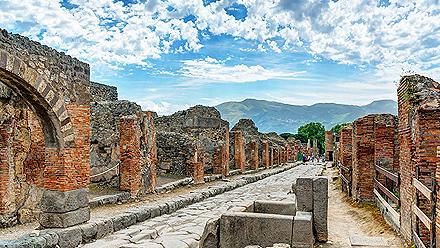Ruins of buildings along a stone street in Pompeii, Italy