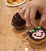 Woman Decorating her Cupcake as a Bear