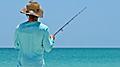 An unidentified local young man on the beach fishing in the shallow water of the Gulf of Mexico.  